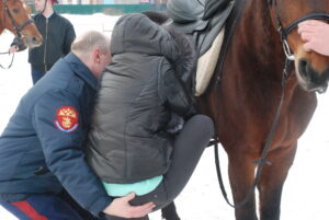 мужчина подсаживает женщину на коня